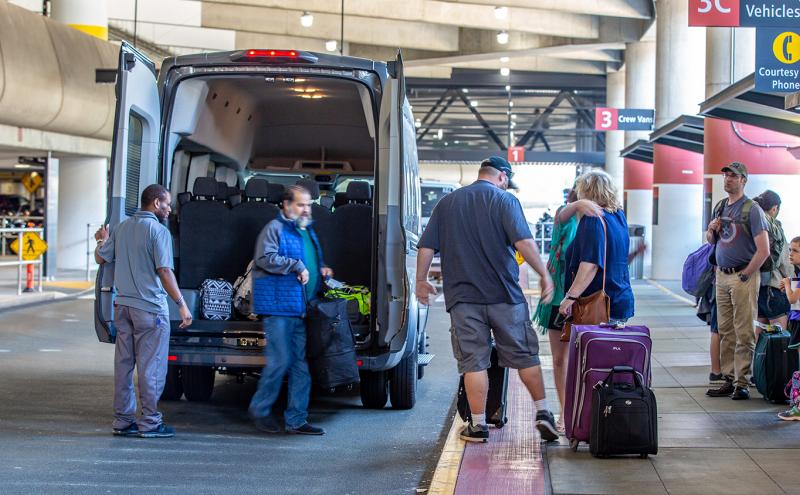 Shuttle passengers disembark from a shuttle at Sea-Tac Airport, June, 2018