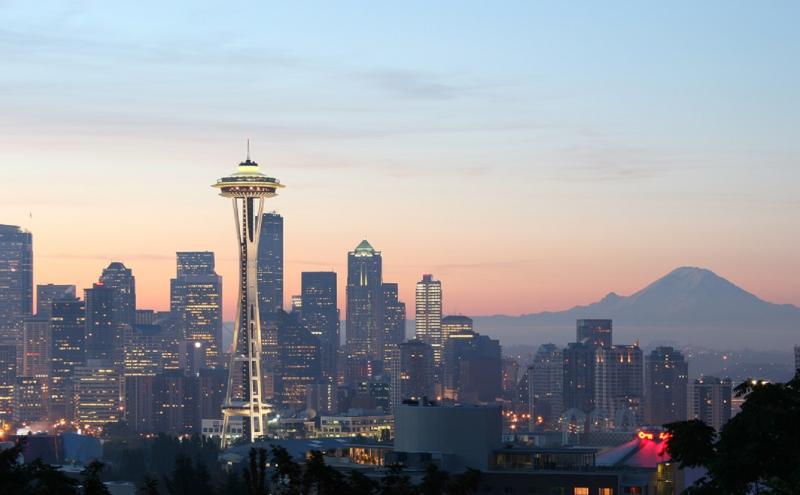 Seattle skyline at sunset with Mount Rainier in the background and Space Needle in the foreground. 