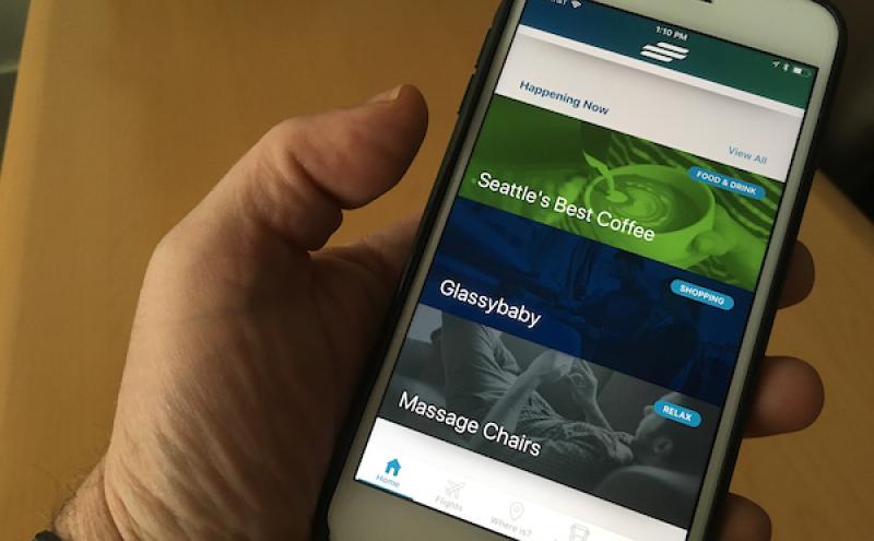 Person holding a phone with the SEA Airport App open