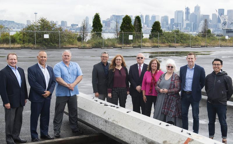 Northwest Seaport Alliance managing members, Directors, Executives, a Local 19 Longshore Worker representative, and SSA Terminal Representative pose at Terminal 5, a container terminal at the Port of Seattle. The group assembled for the groundbreaking project to modernize the terminal.