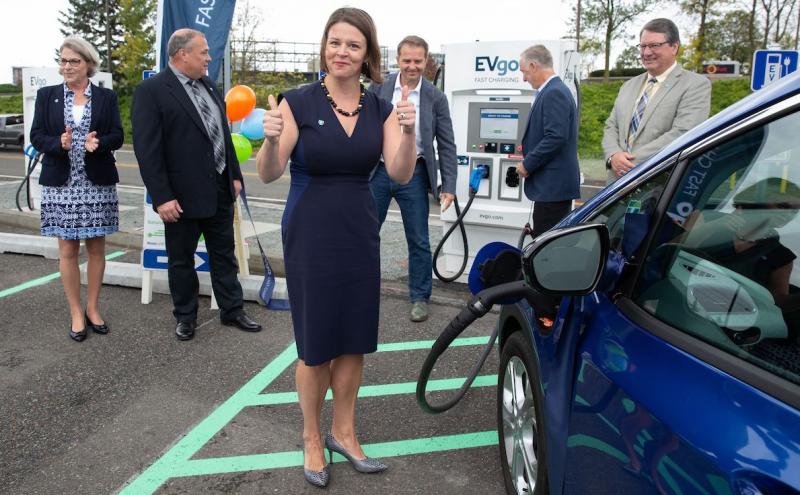 Commissioner Courtney Gregoire with an EV charging station at the airport.