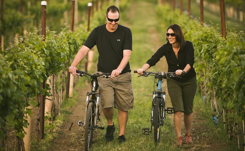 Couple walking bicycles through a winery in Yakima, WA