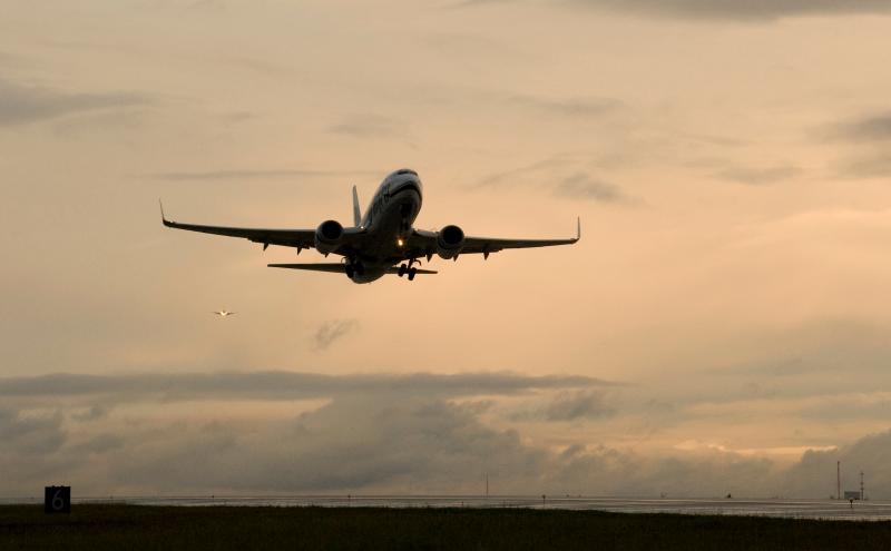 Ascending airplane shortly after takeoff silhoutted on a pink sky, SEA Airport, Nov. 2008