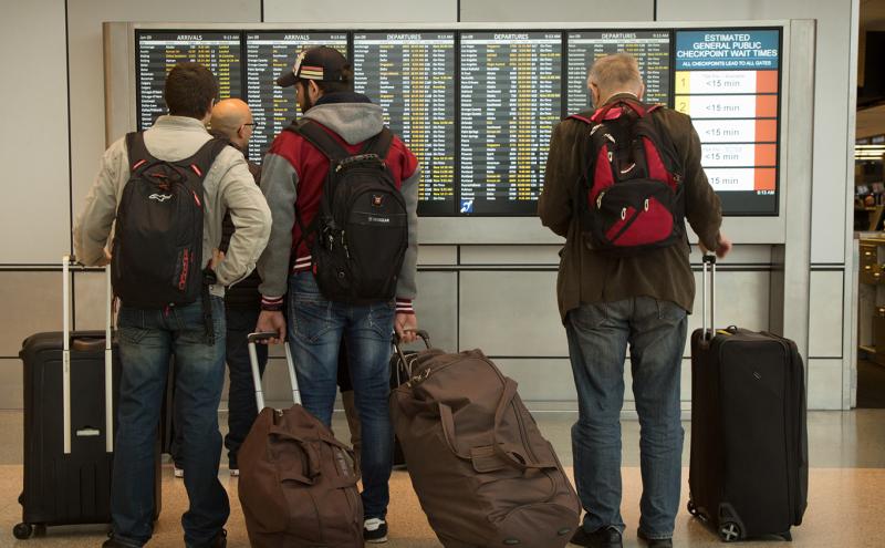 Passengers look at the flight information at SEA Airport, Jan. 2020