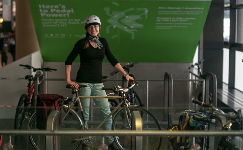 Traveler smiling with bike and entering the rack locations on baggage claim. 