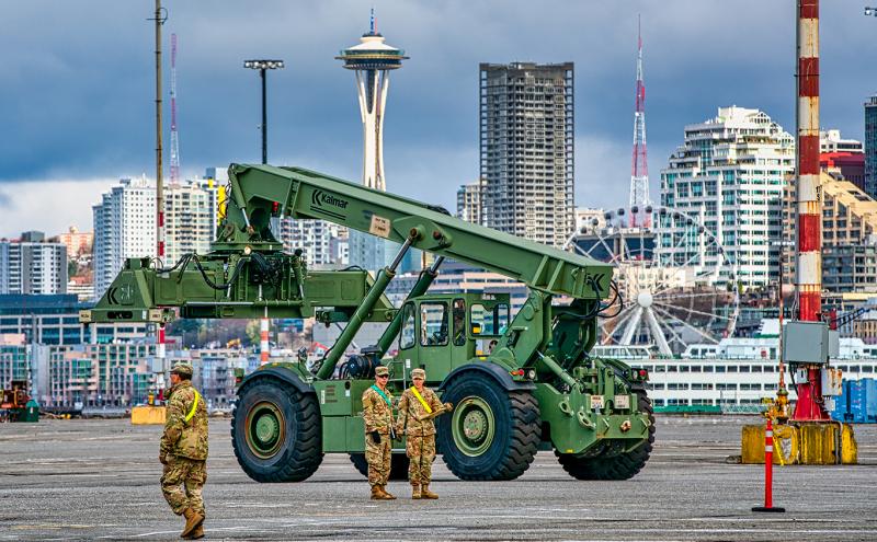 Members of the military oversee equipment at Terminal 46 in preparation to set up a field hospital at Century Quest Events Center.