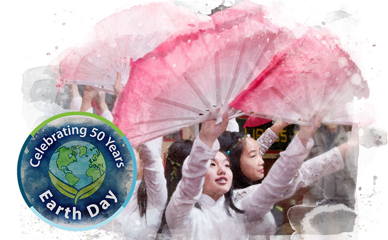 Vietnamese dancers at an environmental celebration with pink fans.