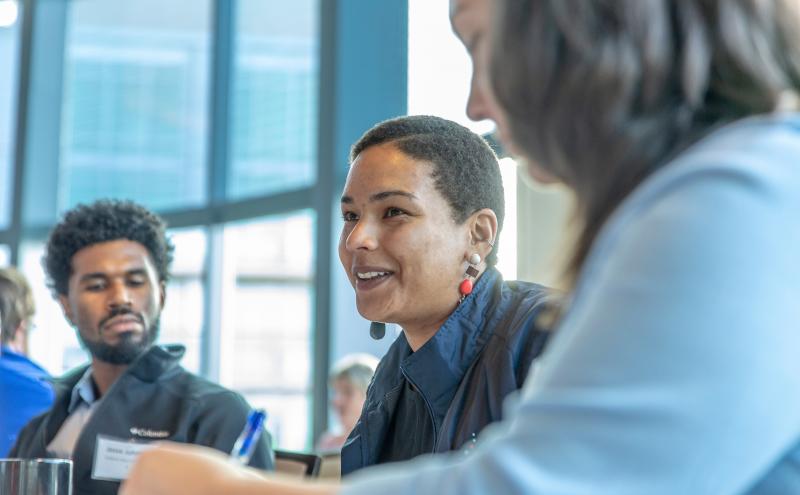Zoomed in image of three participants talking during a round-table discussion.