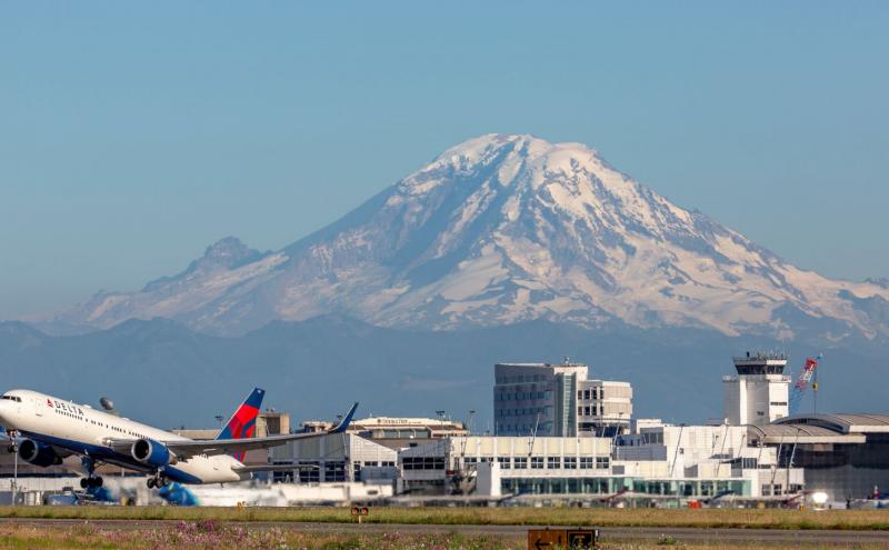 Delta airlines jet takes off from SEA Airport in front of Mt. Rainier.