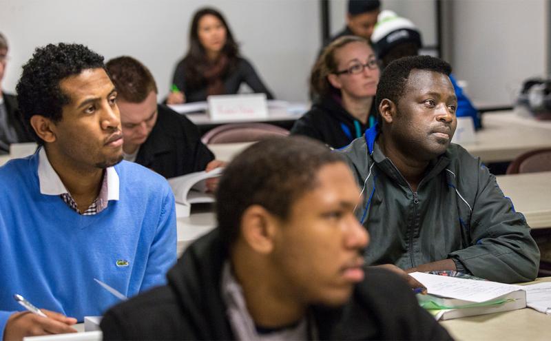 Airport employees in a classroom setting, intently looking at the front of the room