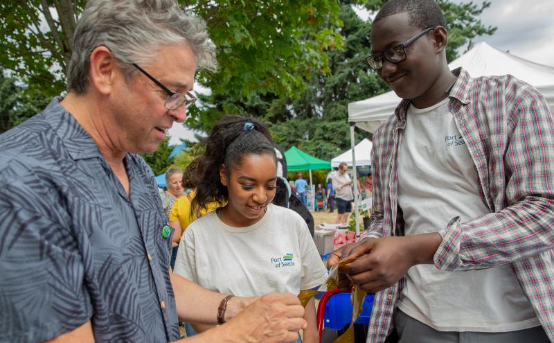 Commissioner Felleman holds kelp and educates students.