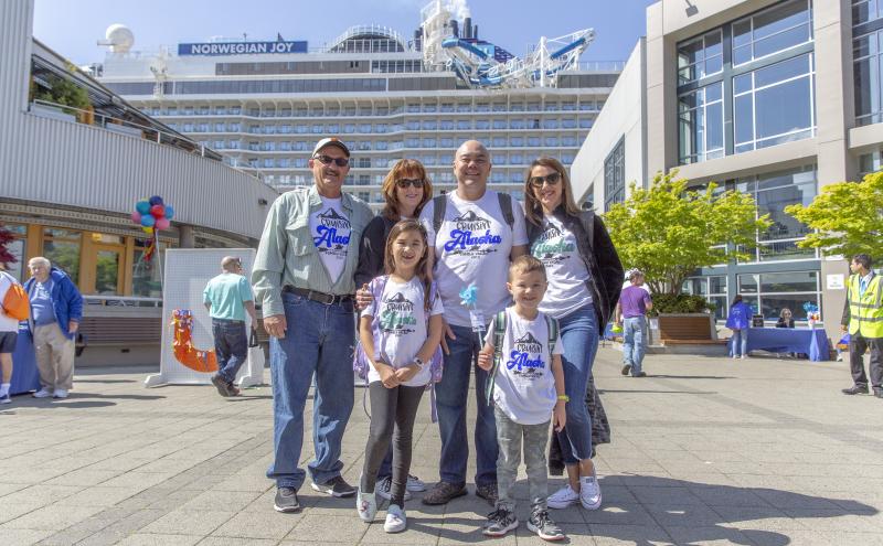 Cruise passengers smiling in front of Bell Harbor Cruise Terminal.
