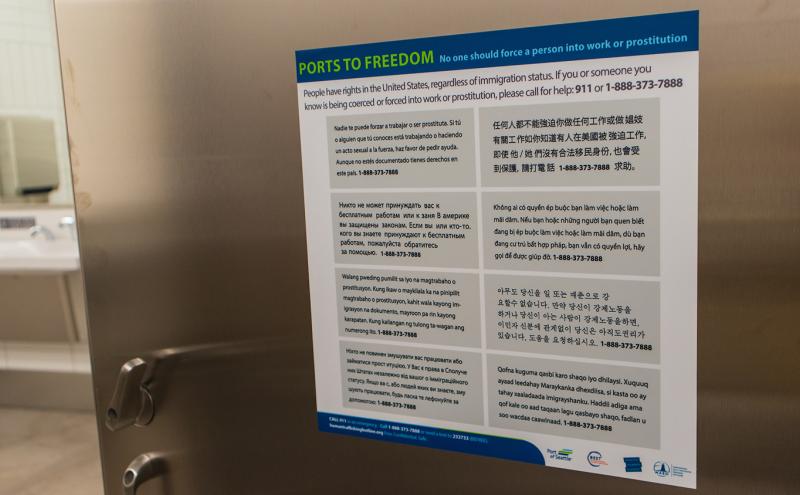 Human Trafficking Prevention sign in multiple languages are in restroom stalls at SEA Airport, Jan. 2021