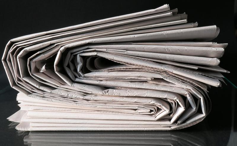 Stacked newspapers viewed from the side.