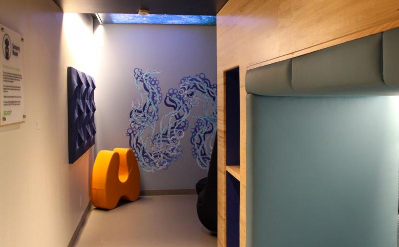 The inside of the sensory room with seating nook, furniture, and artwork