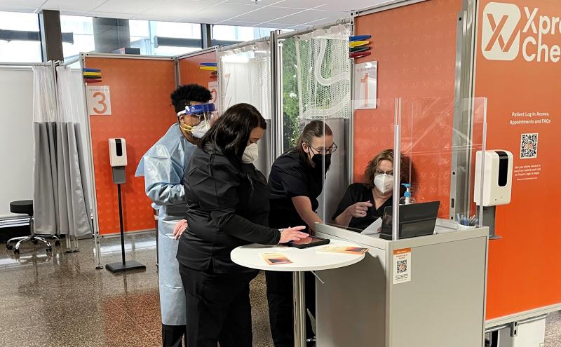 Technical staff at XpresCheck COVID-19 Test site confer at a workstation on April 7 2021 at SEA Airport.