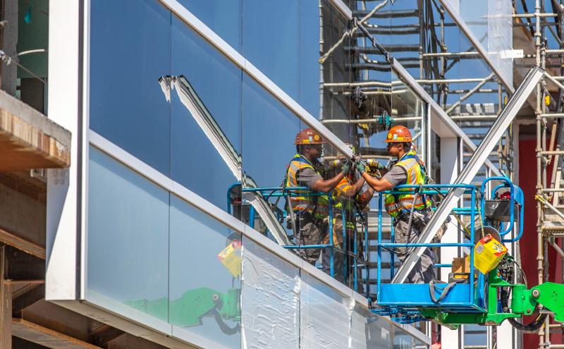 Construction worker working on the exterior of an SEA Airport structure. 