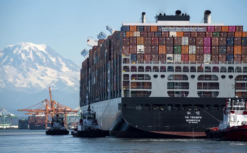 Cargo ship gets piloted by tugs into the Port of Tacoma WA