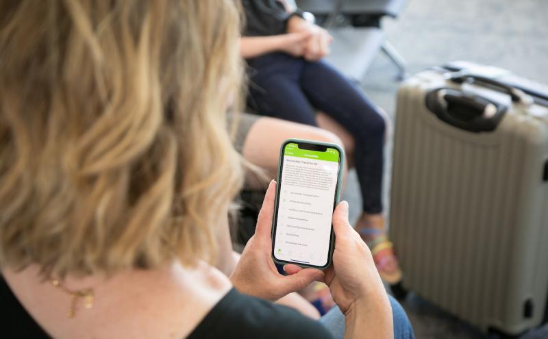 Woman checking cell phone while sitting at the airport