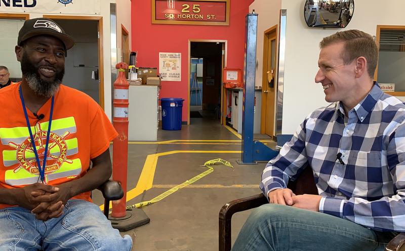 Sprinkler Fitter Crew Chief George Washington talks with Commissioner Calkins at Marine Maintnance shop.