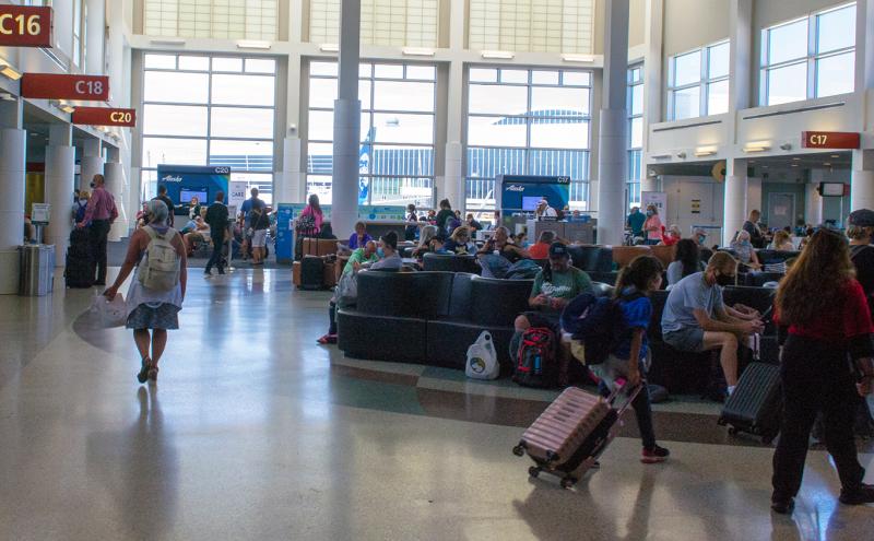 Passengers make their way to the C gates and mingle at the comfy seats at SEA Airport in June 2020
