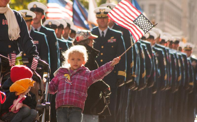 Young girl waves a flag at Veterans Day Parade in New York City