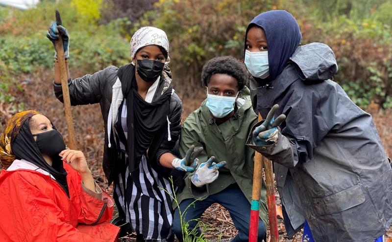 Group of students goofing around as they pose for with shovels at a Hilltop tree planting event
