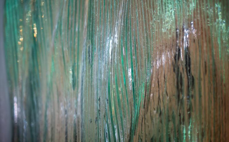Close-up detail of the glass surface showing wave forms visible through translucent material. 