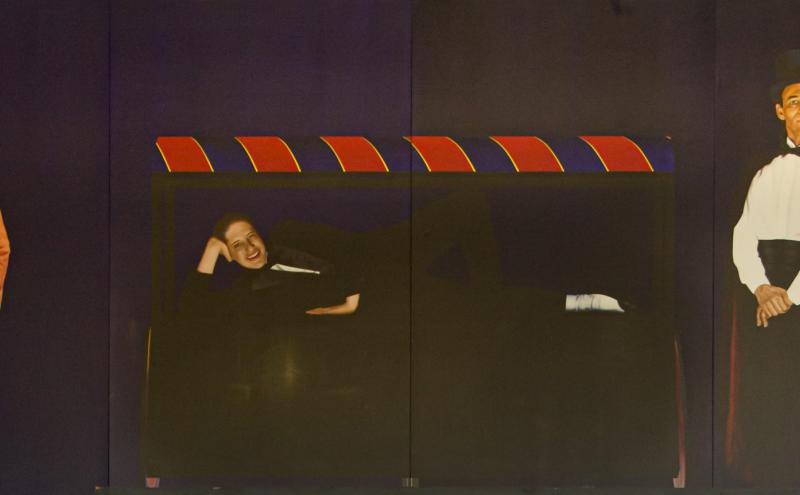 Painted panel showing a person reclining inside the open box.