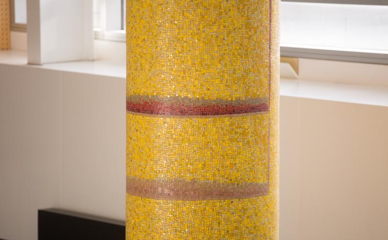 Close-up of the mosaic column surface showing thousands of small square tiles. 