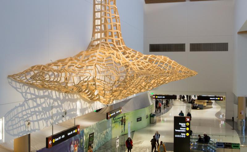 A wide view of the sculpture cantilevering from the wall above the North Satellite concourse. 