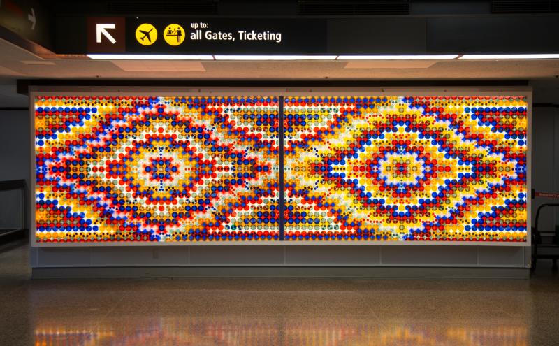 Two large backlit panels, each with circular reflectors arranged in concentric rings forming an oval eye shape at the center