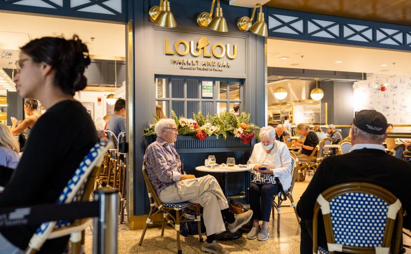 A photo of LouLou Market and Bar; travelers are sitting at tables and dining