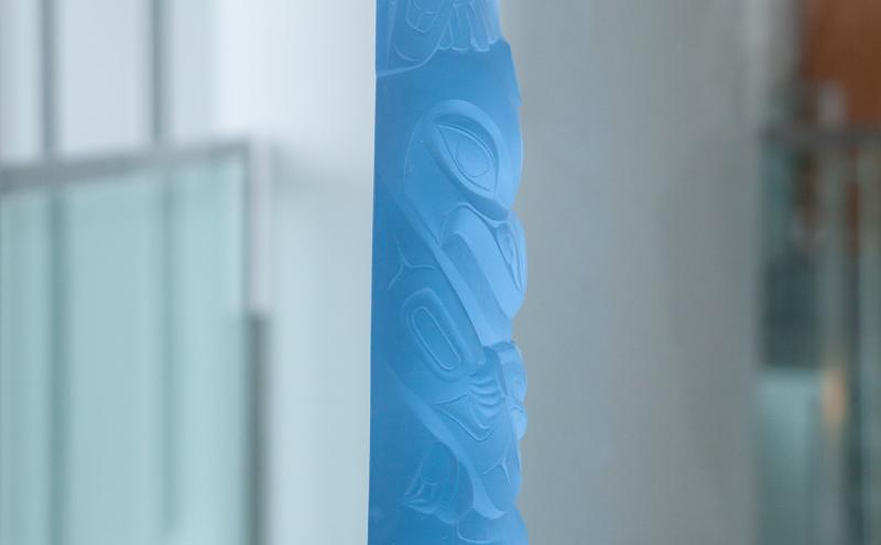 Side view of the crystal totem-form sculpture showing the carved figures. 