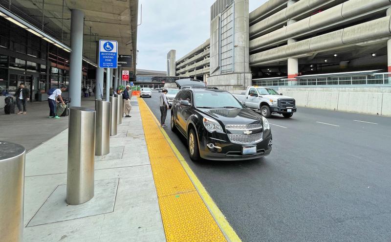 Cars on zero-grade curb on Arrivals Drive.