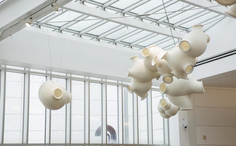just a view of the clouds hanging from the ceiling one cluster and a couple by themself