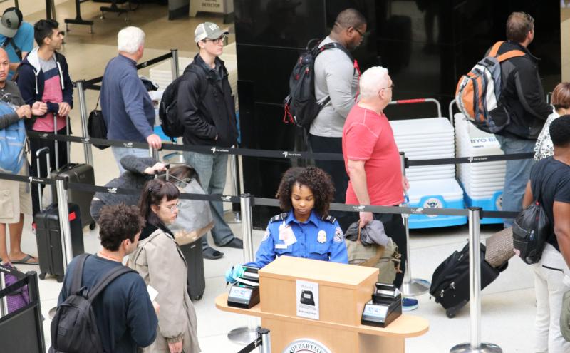 People traveling through TSA security checkpoints at SEA Airport