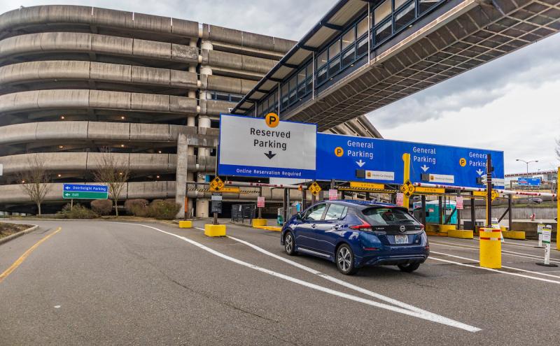 A blue car entering the SEA airport parking garage.