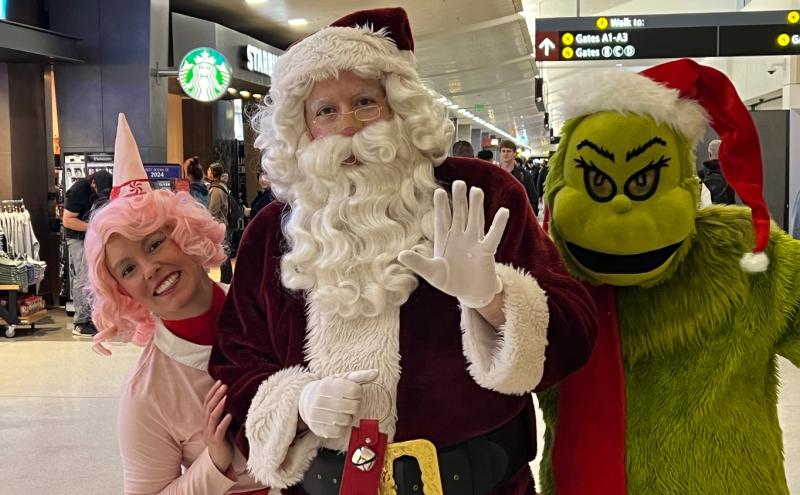 People dressed as Santa and other holiday characters at SEA Airport