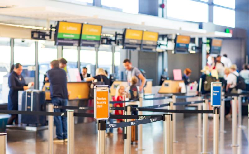 Travelers checking baggage at SEA Airport