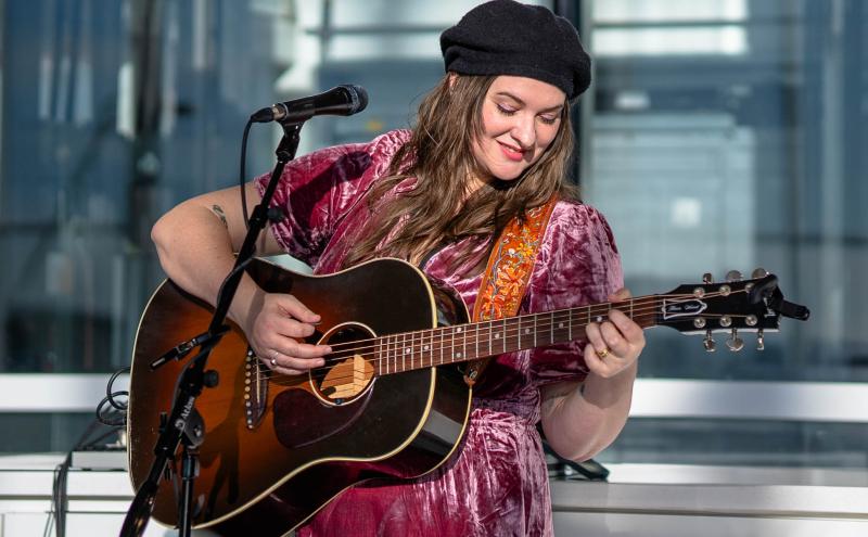 Fleur Wood singing and playing the guitar at Marketplace in N Concourse. 