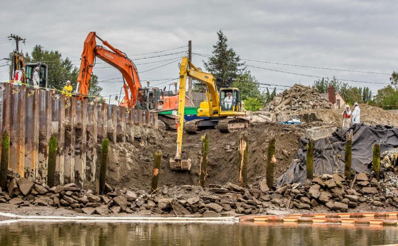 Two excavators move dirt during cleanup at Terminal 117.