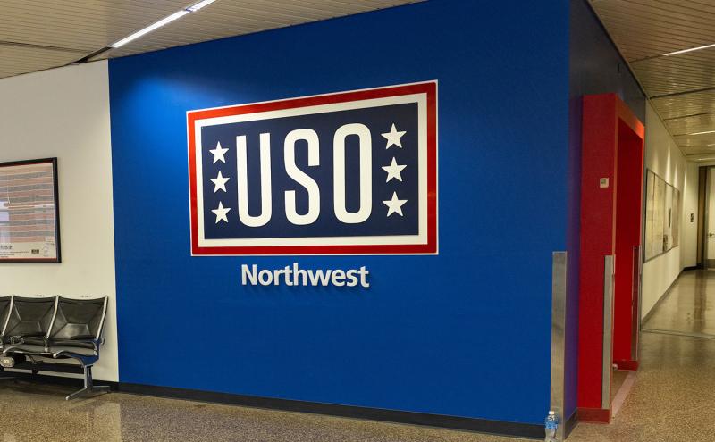 Wall sign reading 'USO Northwest' in an airport hallway.