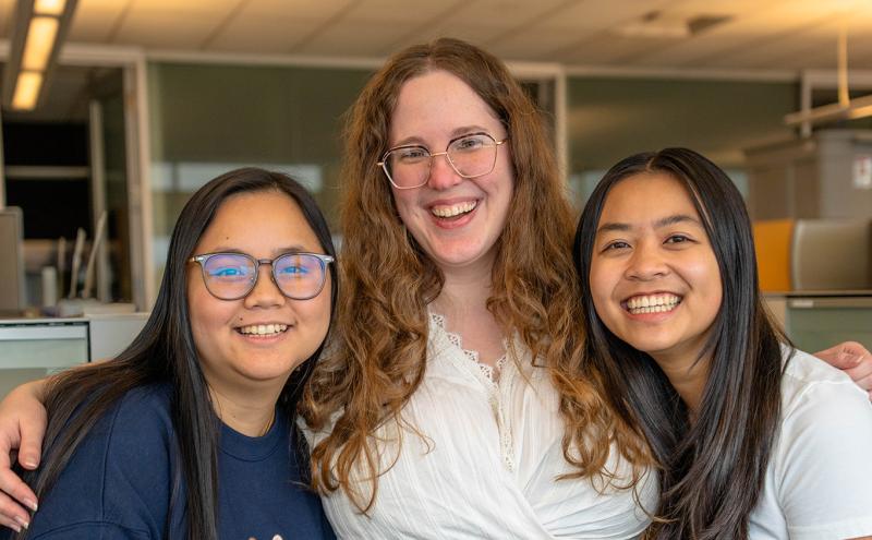 Dianne, Trudy, and Raeanna, stand close together in an office setting.
