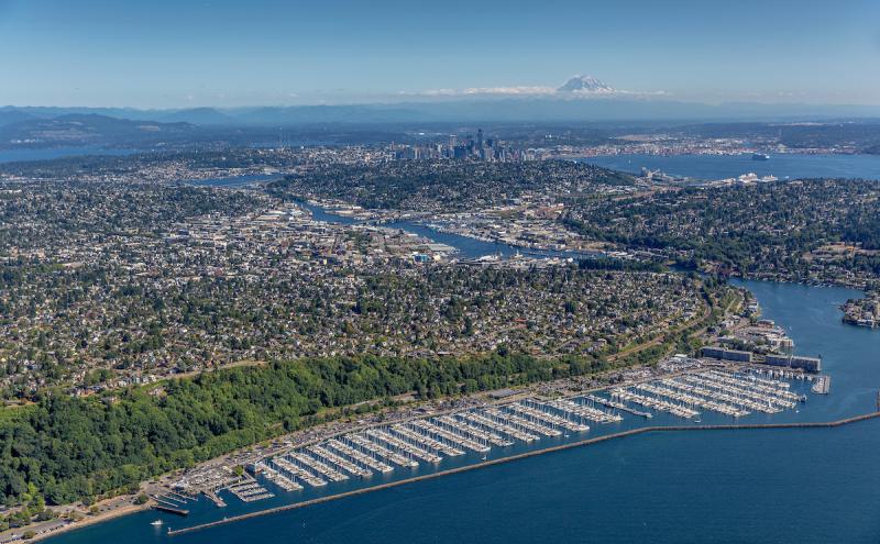 An aerial photo of Shilshole Bay Marina from the northwest. The ship canal, Elliott Bay, downtown Seattle, and Mount Rainier are visible in the distance..