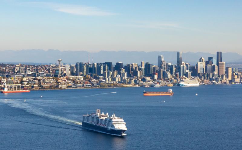 Aerial photo of the Seattle waterfront with a cruise ship leaving the city and another at port
