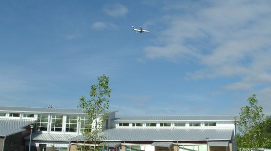 Image of school with airplane flying overhead