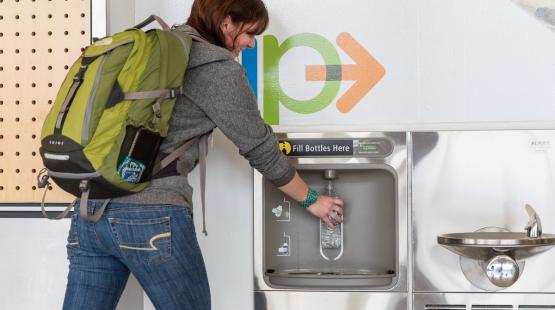 Customer filling bottle at a refill station 