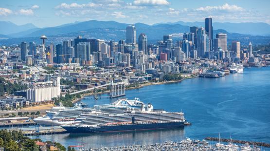 Cruise ship docked with the Seattle skyline in the background.