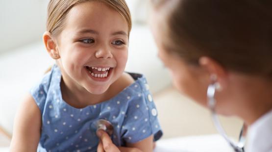 Doctor checks smiling girls heart-rate